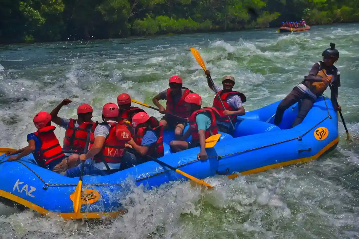 Rafting group paddling through white water rapids with guide on Kali River, Dandeli