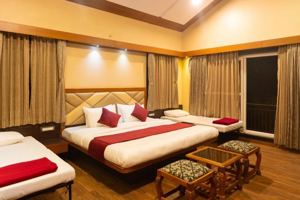 Spacious AC Deluxe room with TV and forest view window at Dew Drops Resort