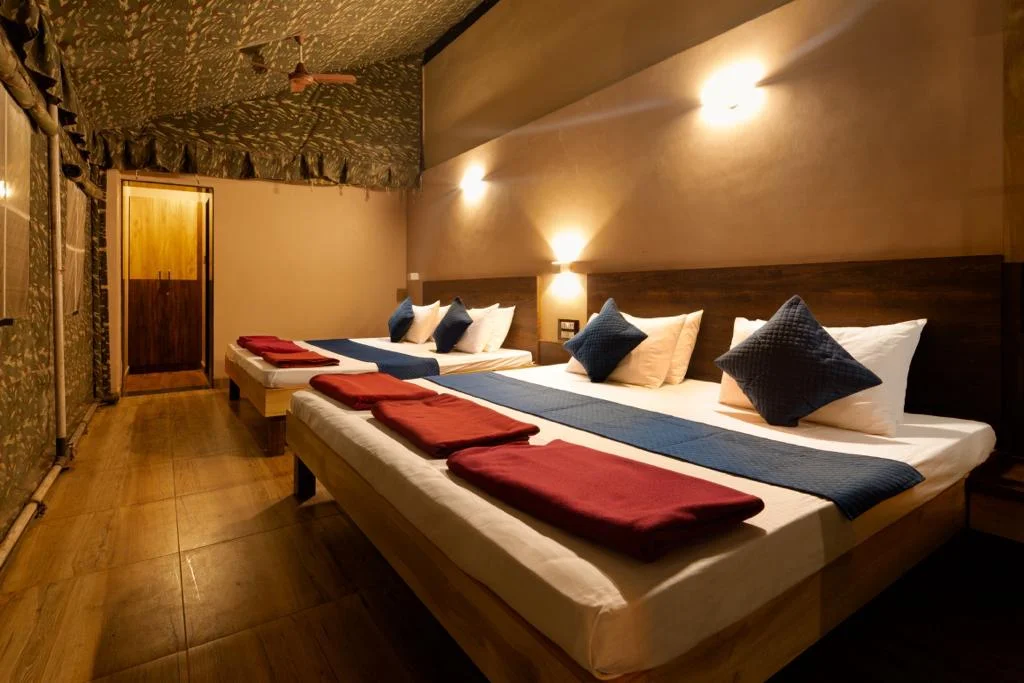 Cozy commando cottage bedroom with dormitory-style bedding at Dew Drops Resort